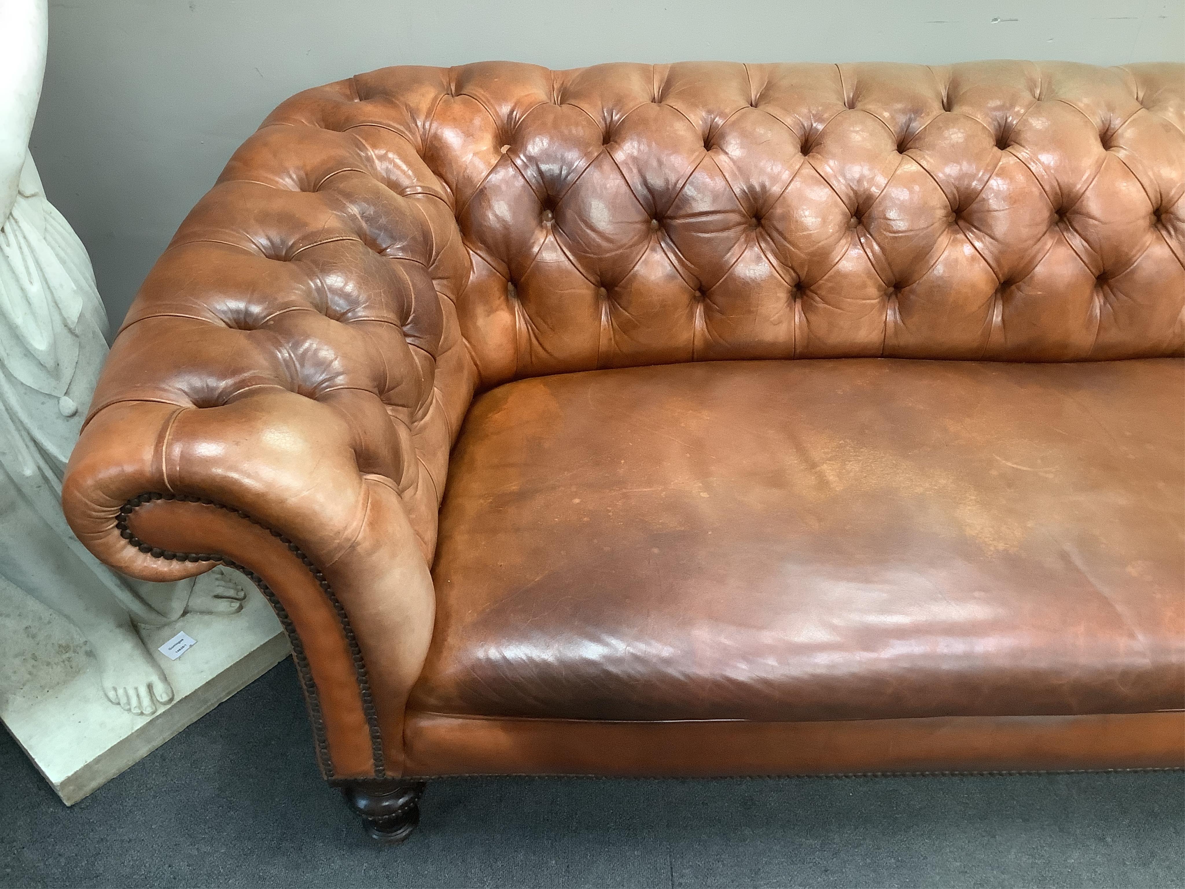 A Victorian chesterfield settee upholstered in hand dyed deep buttoned tan leather, on turned fluted feet, width 210cm, depth 92cm, height 65cm. Condition - good